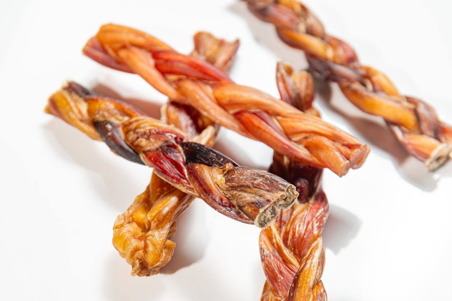 Group of braided bully sticks with varied texture, natural, protein-rich chews ideal for dogs