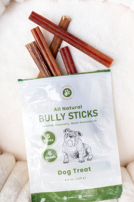 A package of Melico Pawtry All Natural Bully Sticks with several bully sticks partially pulled out and displayed on a soft white surface.