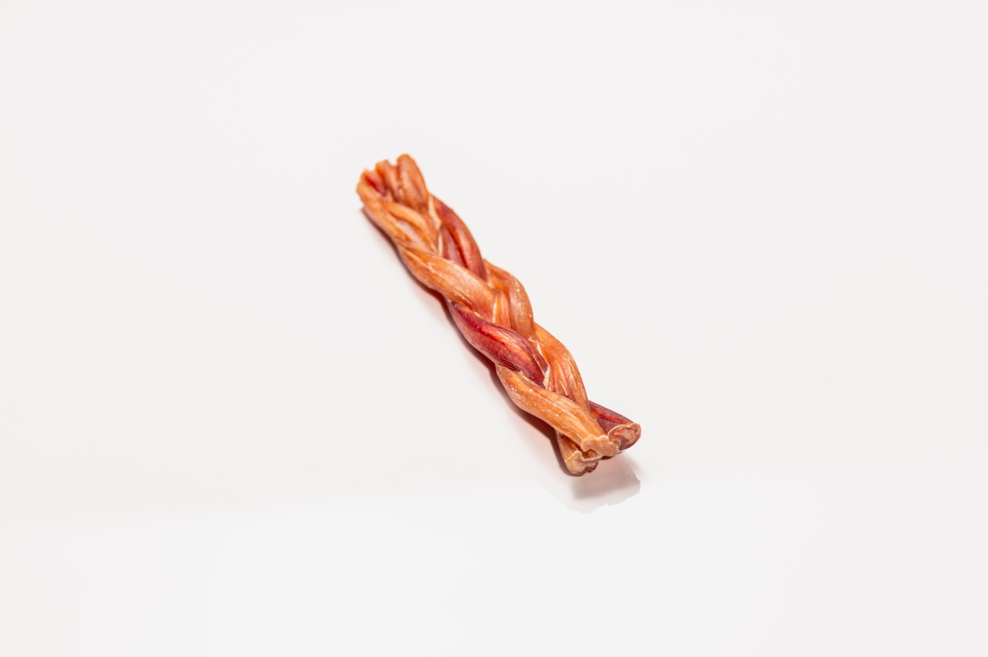 Natural braided bully stick shown on white background, sustainably sourced, digestible chew for dogs